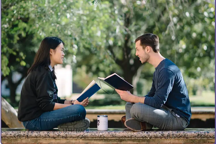 Students sitting on ground.